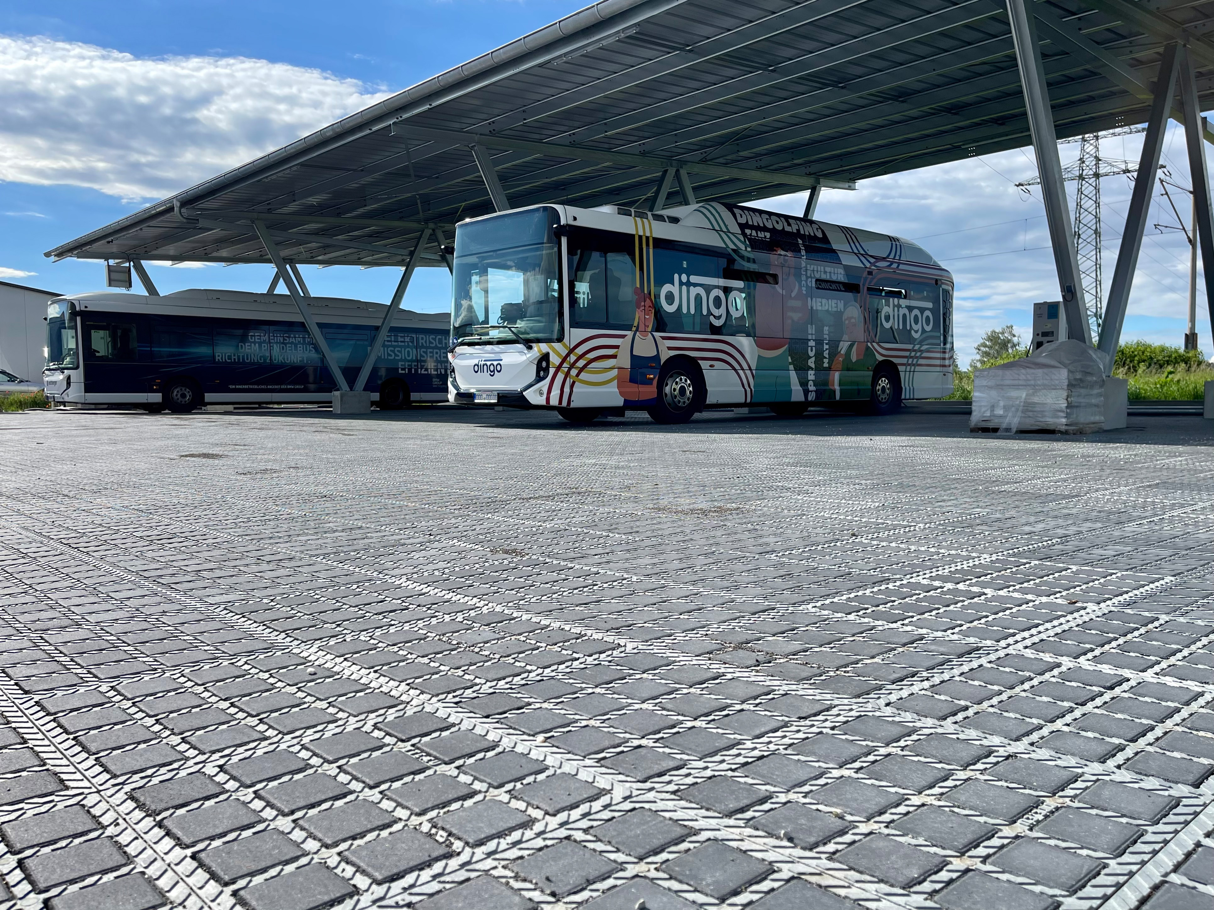 Elektriske busser parkeret under solcelletag